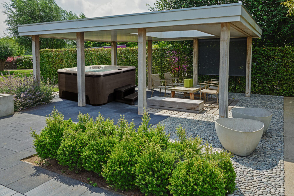 A patio with a roof structure and hot tub.